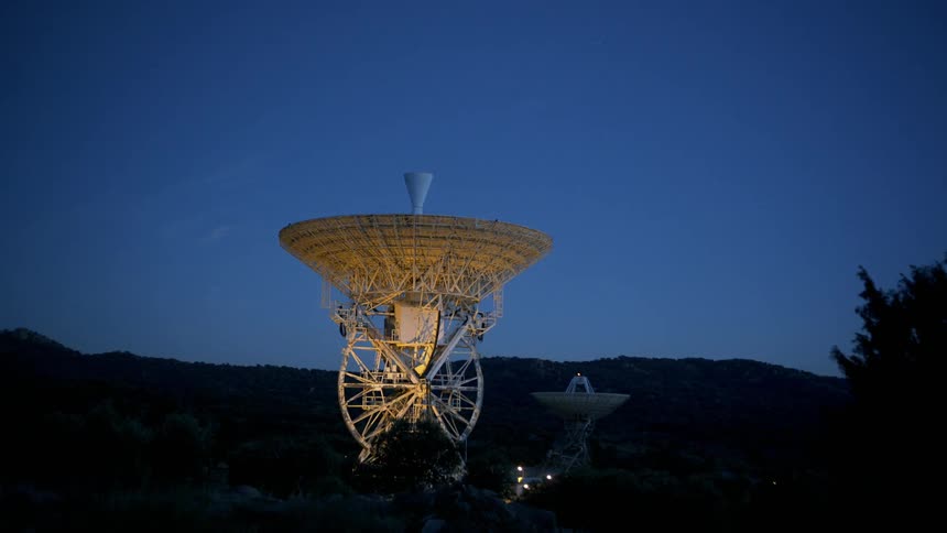 The satellite dish is pointing straight up at the dawn sky