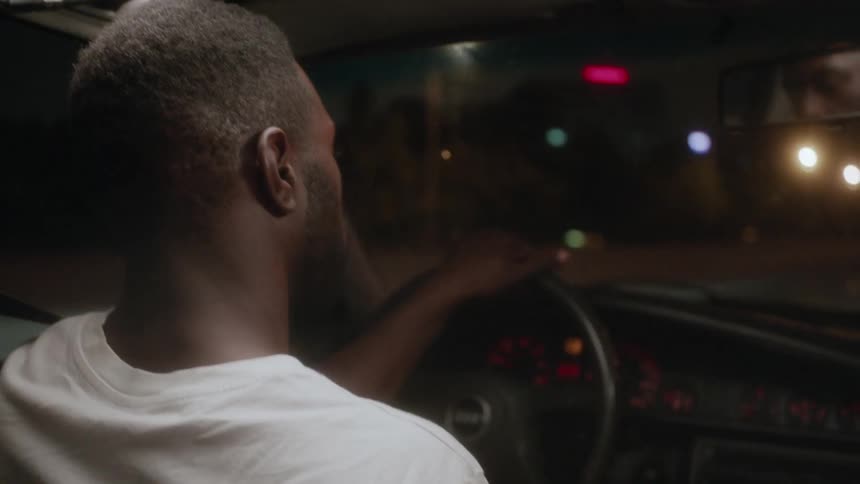 A man is driving his car at night