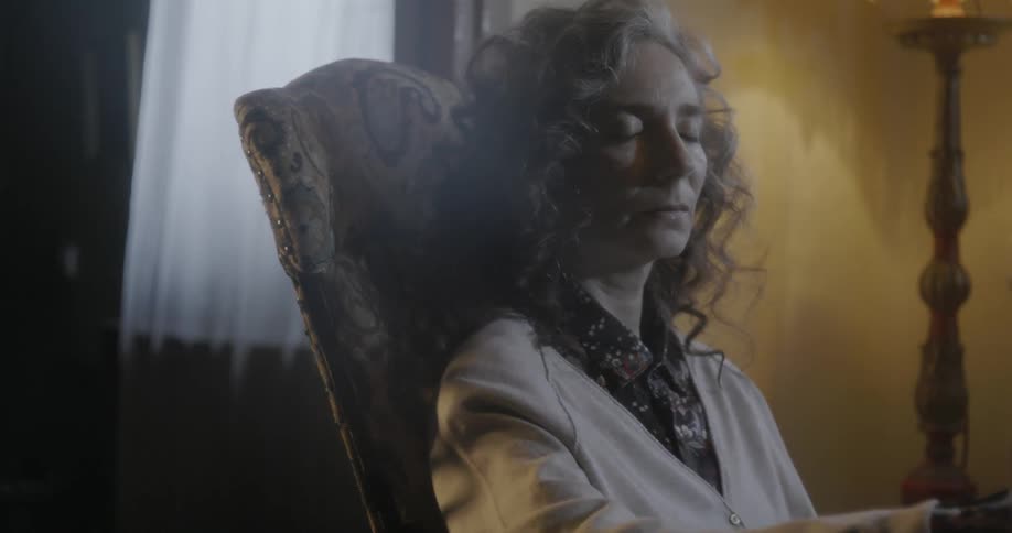 A woman rocks in a rocking chair
