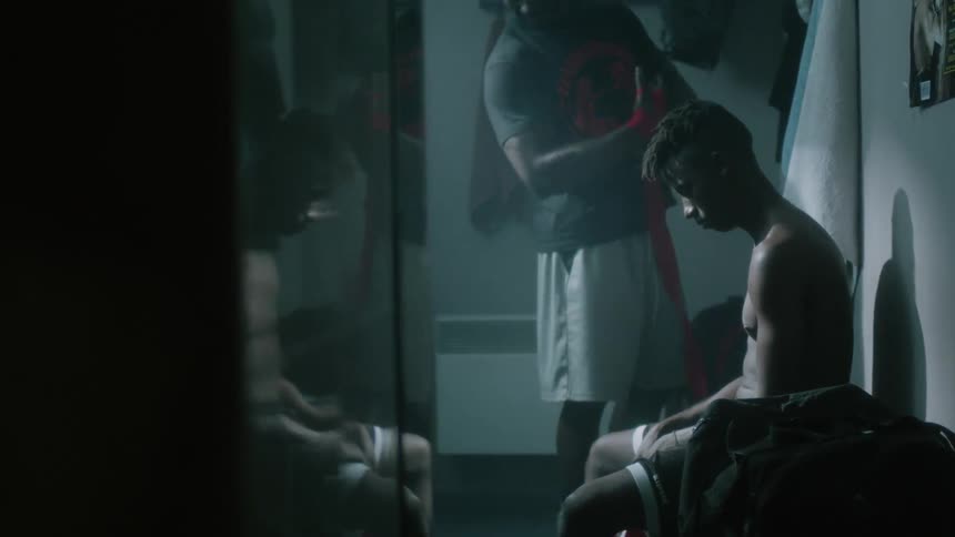 An athlete sits in a locker room