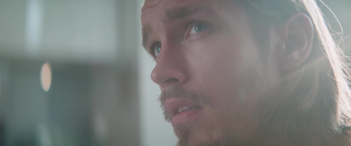 Extreme close up shot of a worried man looking off screen inside house.