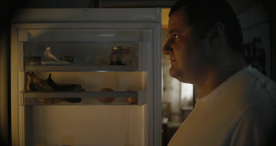 Man standing in a dark area and a light is flashing off and on
