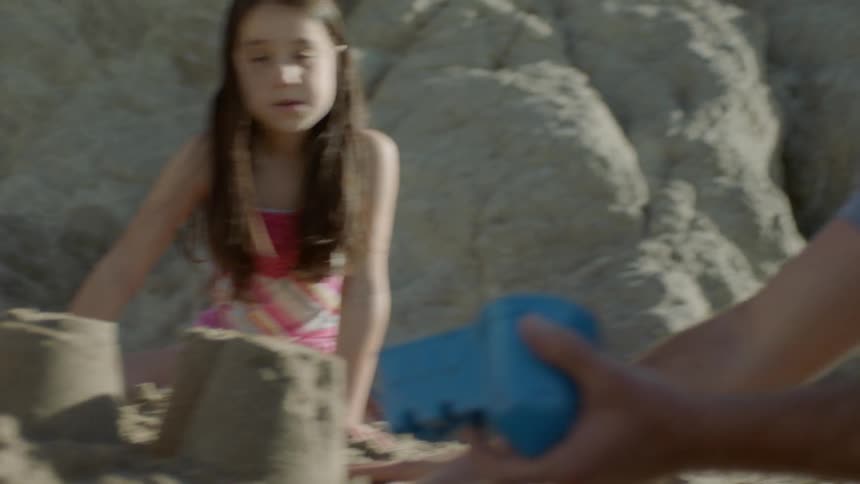 Man helps some kids build sand castles