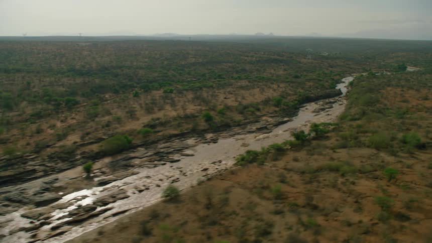 The long stream runs through the hilly field