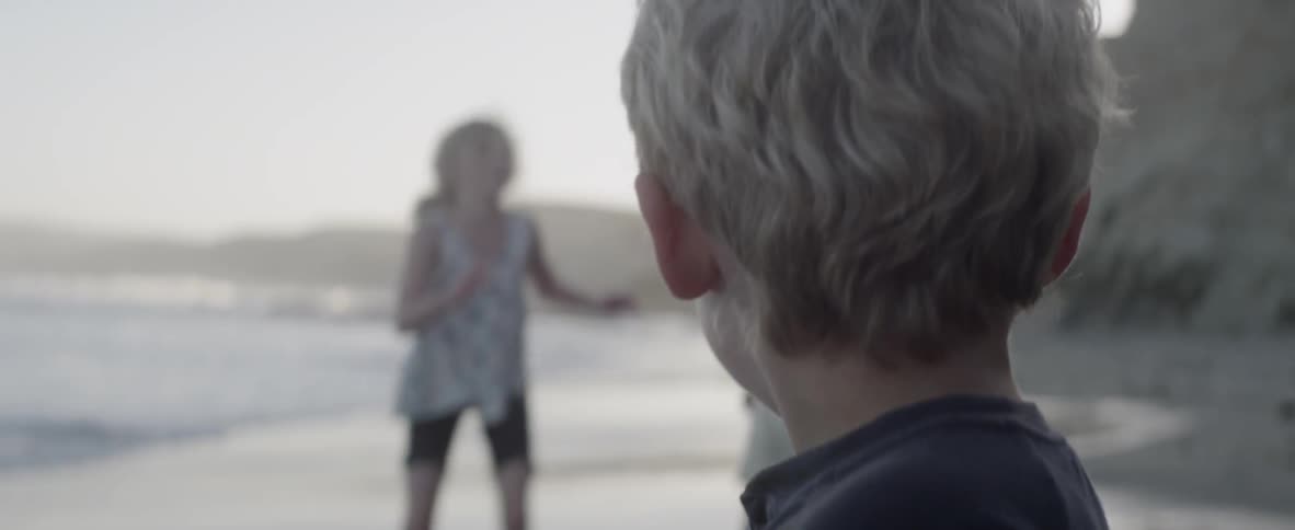 Children play on the beach together on a cloudy day