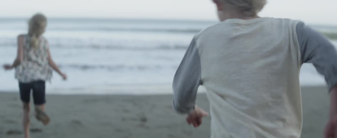 Children run fast together towards the beach water