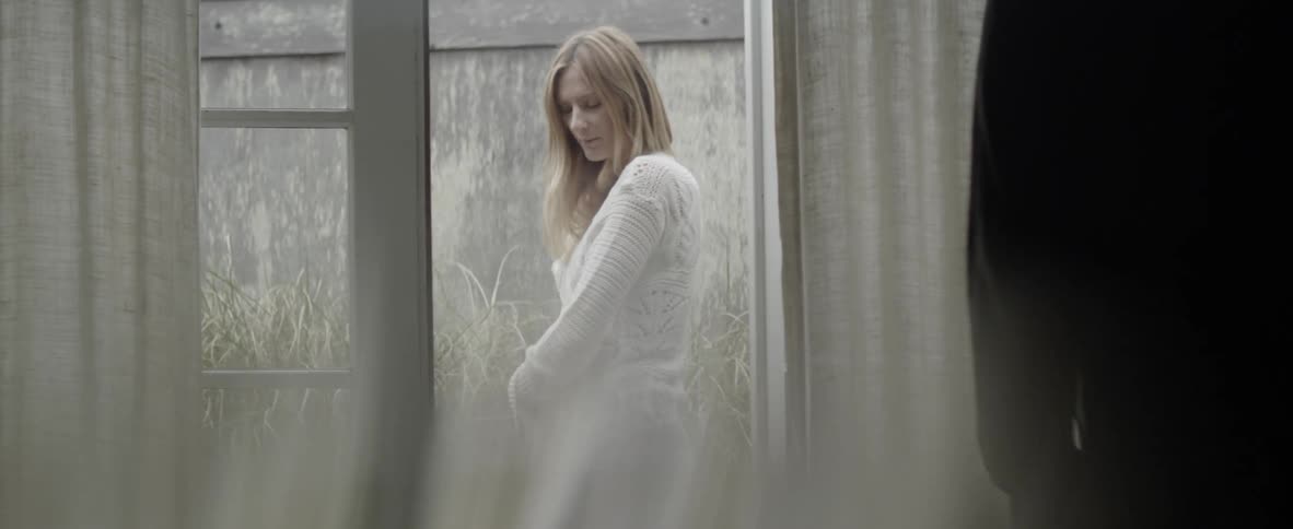 A woman turns looking around the yard outside