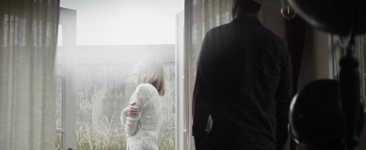 Woman hugs herself as a man approaches