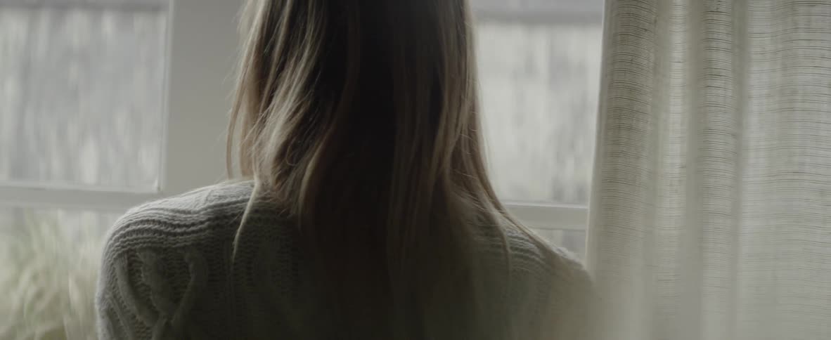 A woman opens the curtains and opens the french doors
