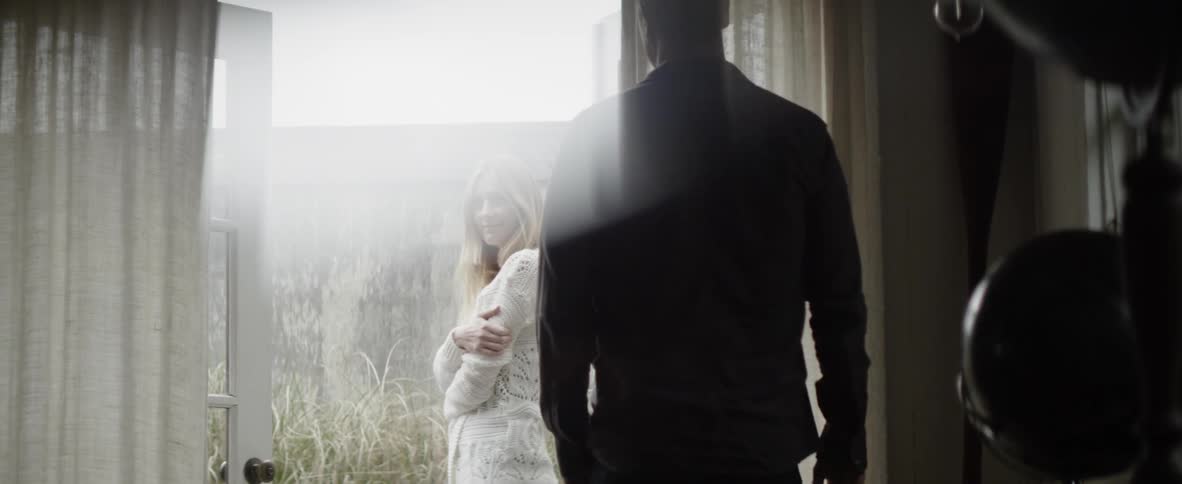 A woman stands in the yard as a man exits the home