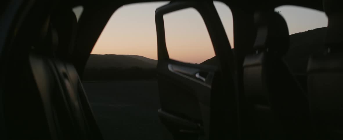 Car with open door in nature at sunset