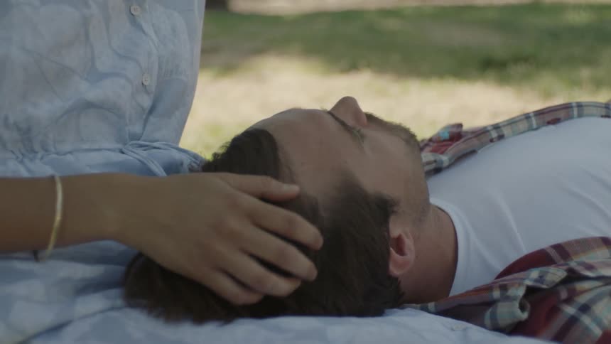 A woman is playing with a man's hair
