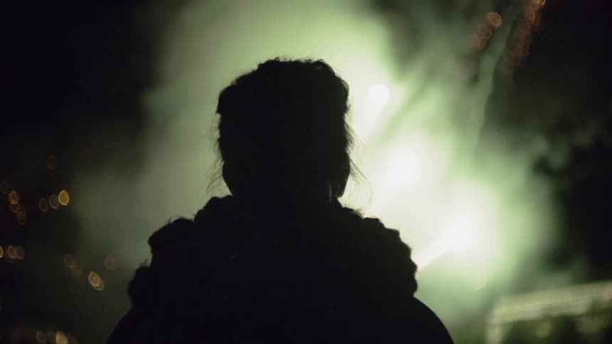 A person watches as the fireworks fly