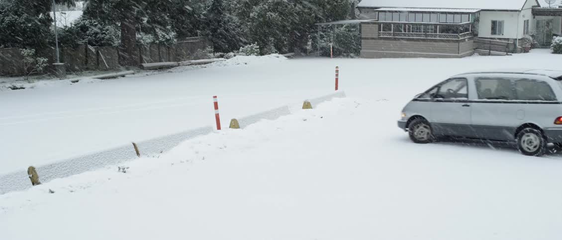 A van parks in a snowy parking lot
