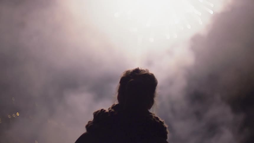 Child watches fireworks in the night sky