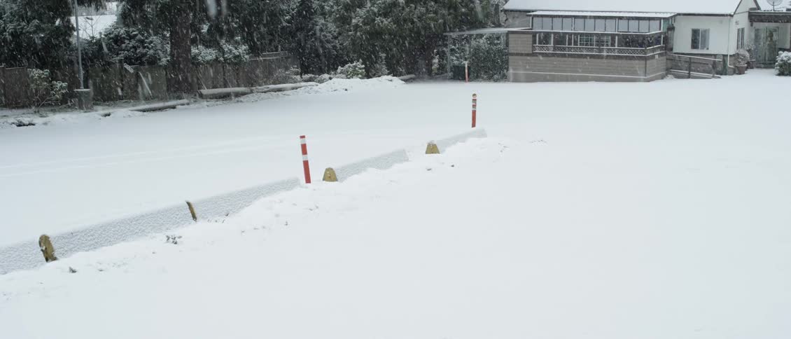 Snow falls in a parking lot