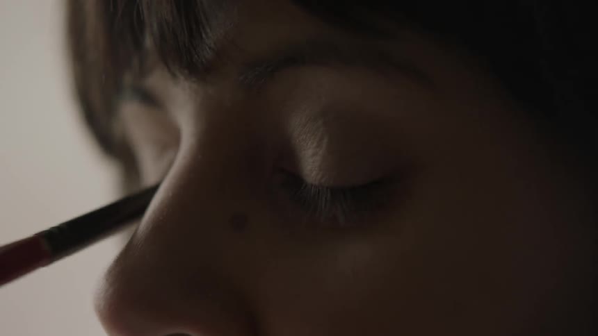 Woman having makeup applied to her eyelids