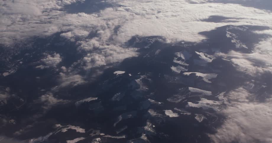 Clouds hang above the tall stone mountains