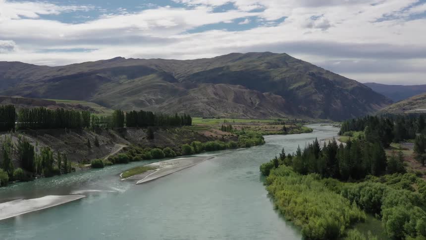 Water flows down a river near the mountains