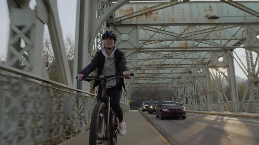 A bicyclist rides across a bridge