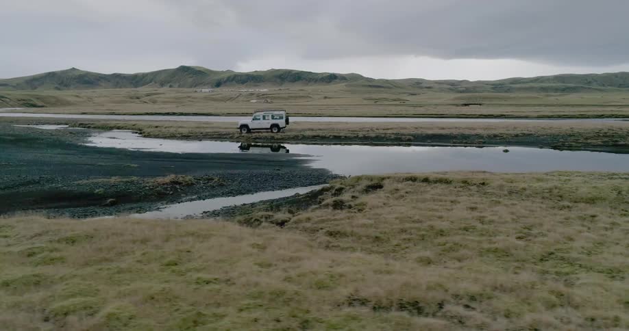 A vehicle drives across a rural field