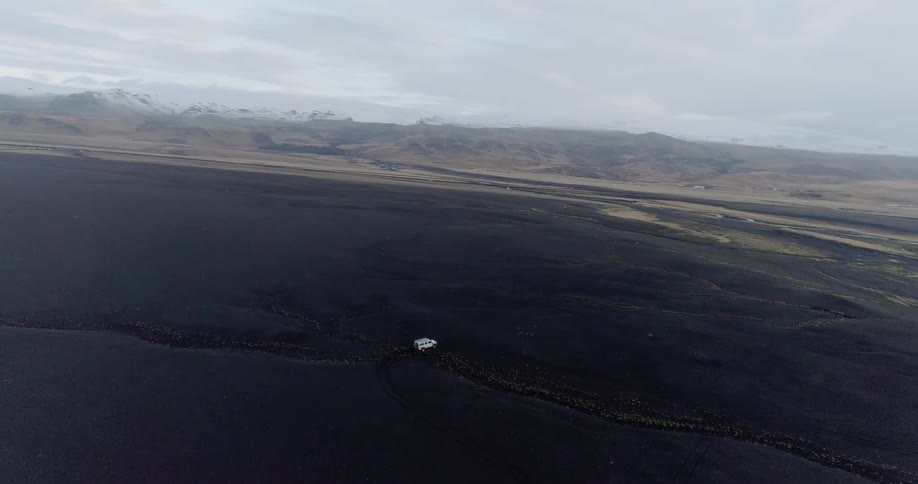A single vehicle travels down the long dark field