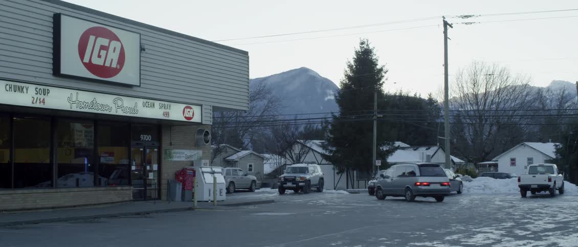 A vehicle drives past the store and parks