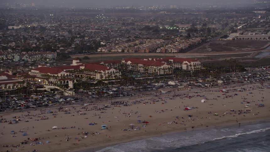 Hundreds of people on a long beach as seen from above