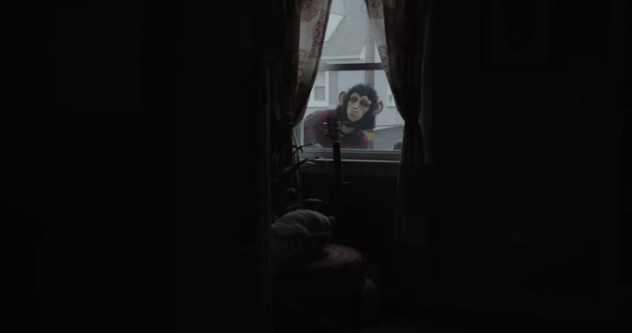 Two people wearing masks looking into a home's window from outside