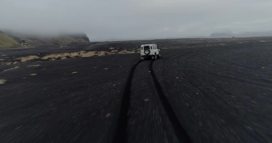 A jeep drives fast over the rough terrain