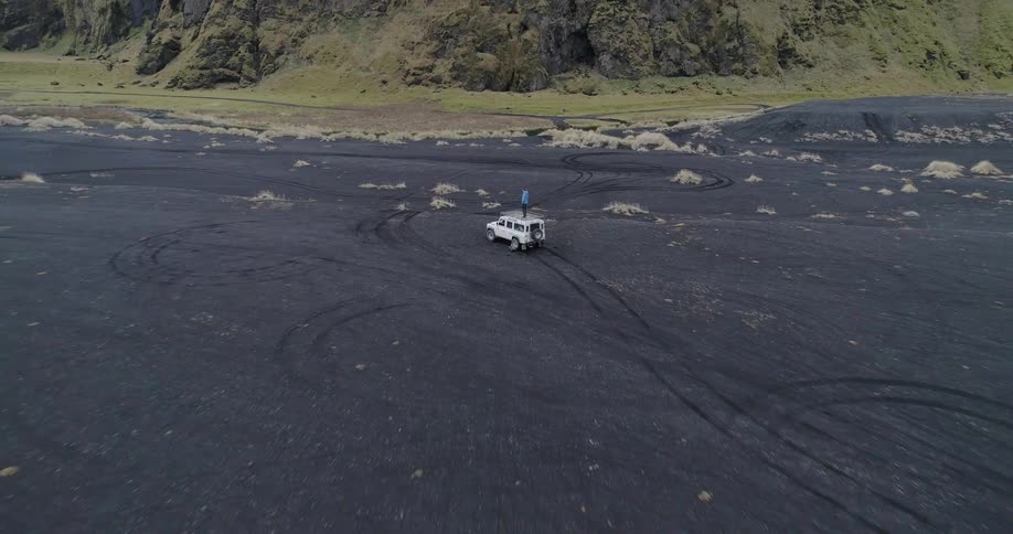 Man standing on top of jeep in the wilderness