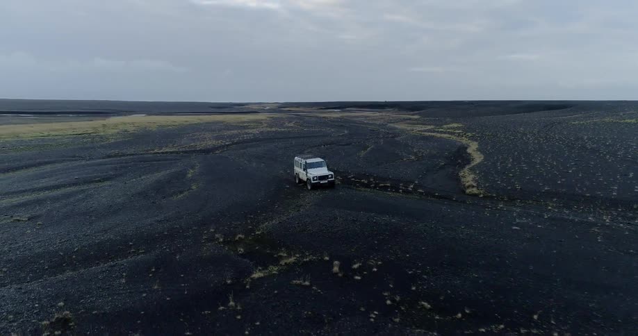 A jeep is sitting in a black dirt field