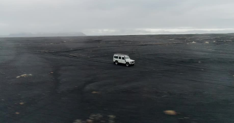Jeep travels over the land under a cloudy sky