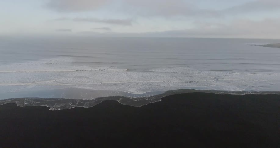Ocean waves wash ashore a sandy beach