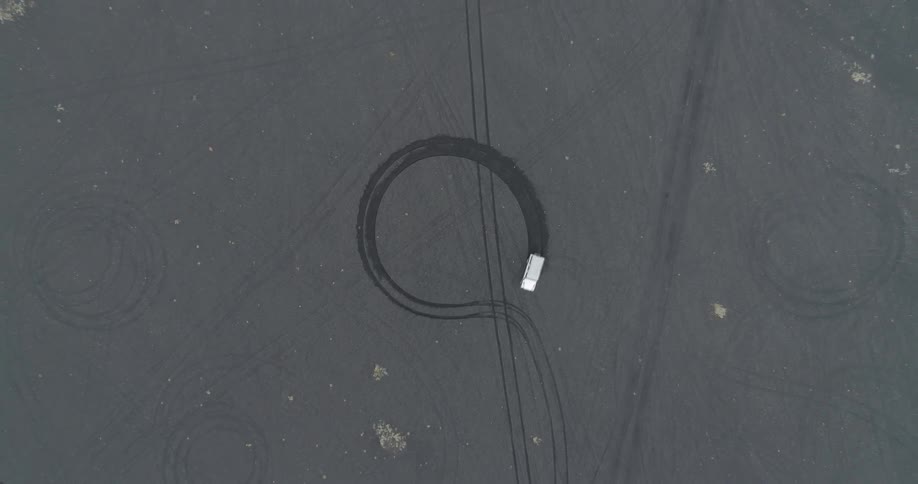 A car drives in circles in a dirt field