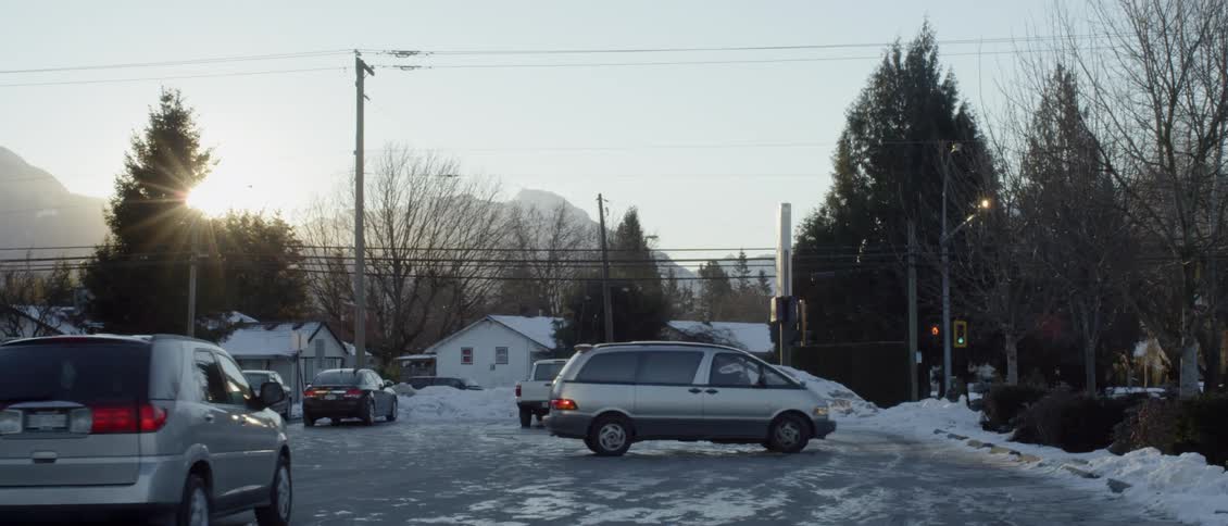 Several cars drive in a parking lot and park
