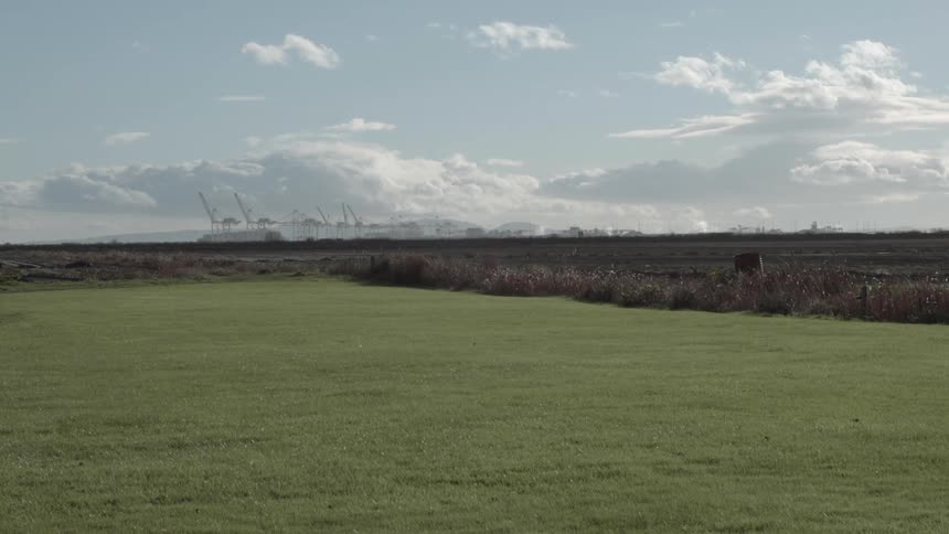 Green fields sit under white clouds and a blue sky