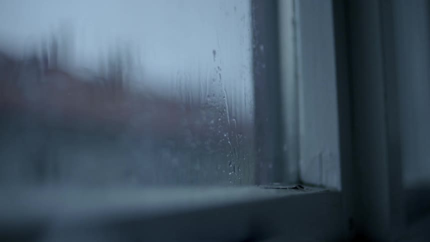 Rain water is dripping down the outside of window