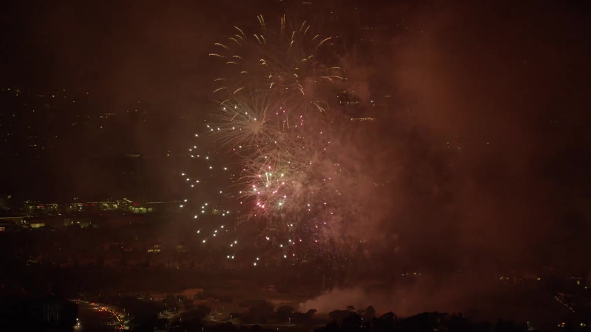 Fireworks explode in the sky above a city