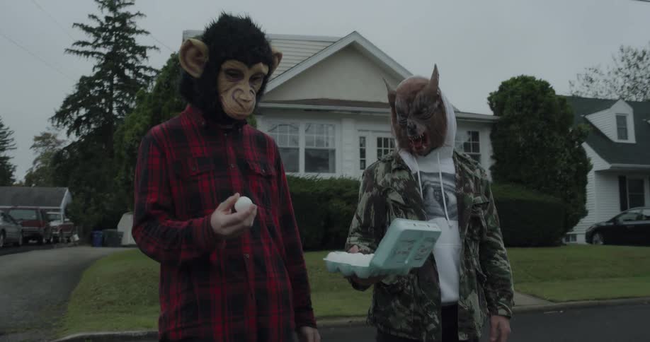 Two people with halloween masks hold eggs in their hands