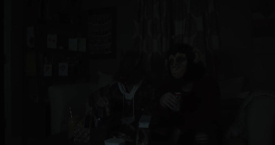 An ape and a wolf sit on a sofa drinking beer