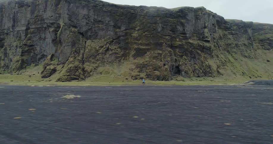 A man jogs on the dirt near cliffs