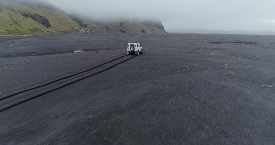 The white vehicle races leaving tracks behind