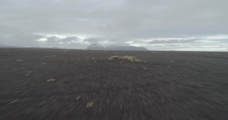 Large piece of land sits under a cloudy sky