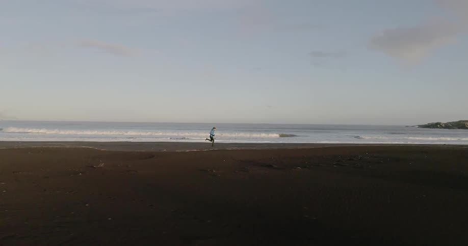 A person runs on a beach