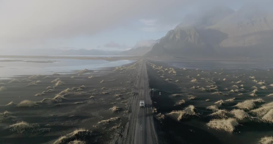 A truck travels on a dirt road towards the water