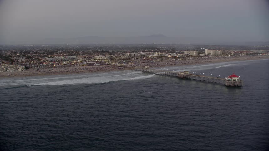 The pier reaches out into the water near the shore town