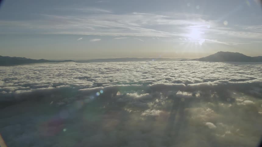The sun is rising over the mountains and clouds