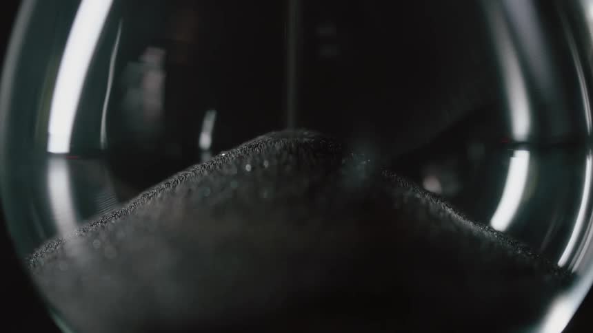 Brown sand like material pours into a clear glass
