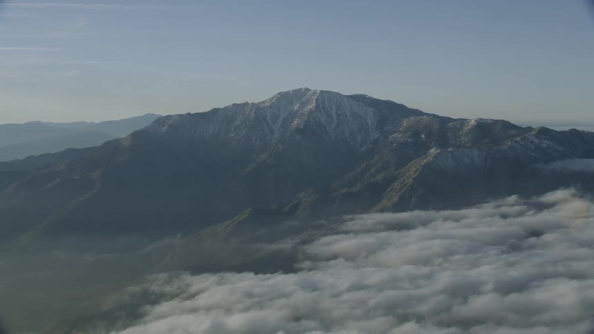 Aerial zoom out of snow capped mountain